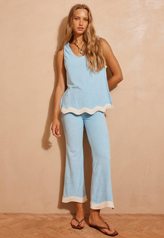 A woman modeling a light blue two-piece lounge set with white contrast trim