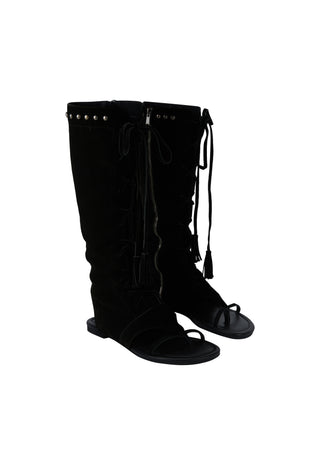 a-pair-of-black-knee-high-boots-with-front-lace-up-detailing-and-small-metallic-studs-near-the-top-shown-against-a-plain-white-background