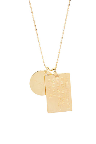 Close up back view of Spell’s Aquarius Stargazer Zodiac Necklace charms. One charm is of a rectangular shape and an inspirational quote while the other charm is circular the brand name.
