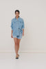 Model, Michelle Bagarra, wearing Spell Classic Chambray Shirt. The long-sleeved, front button-down shirt is made of denim and features two pockets and a collar.