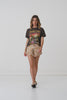 A studio video of model, Annalise McLachlan, wearing the Spell Rolling Valley Biker Tee. The tee comes in a charcoal colourway and features ribbed neckline and a hand drawn print on the front. 